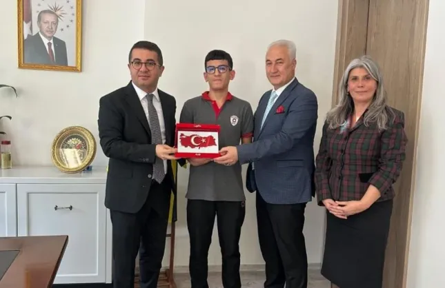 Yere düşen Türk bayrağını öpen öğrenciye kaymakamdan tebrik